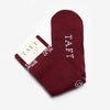 Pair of maroon socks with the brand name TAFT printed in white and a smiley face icon near the toes.