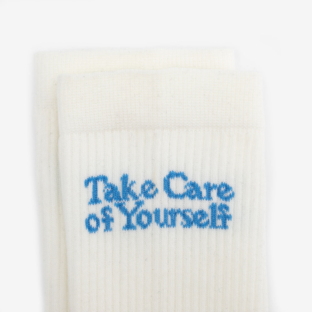 White socks with the text Take Care of Yourself in blue letters.