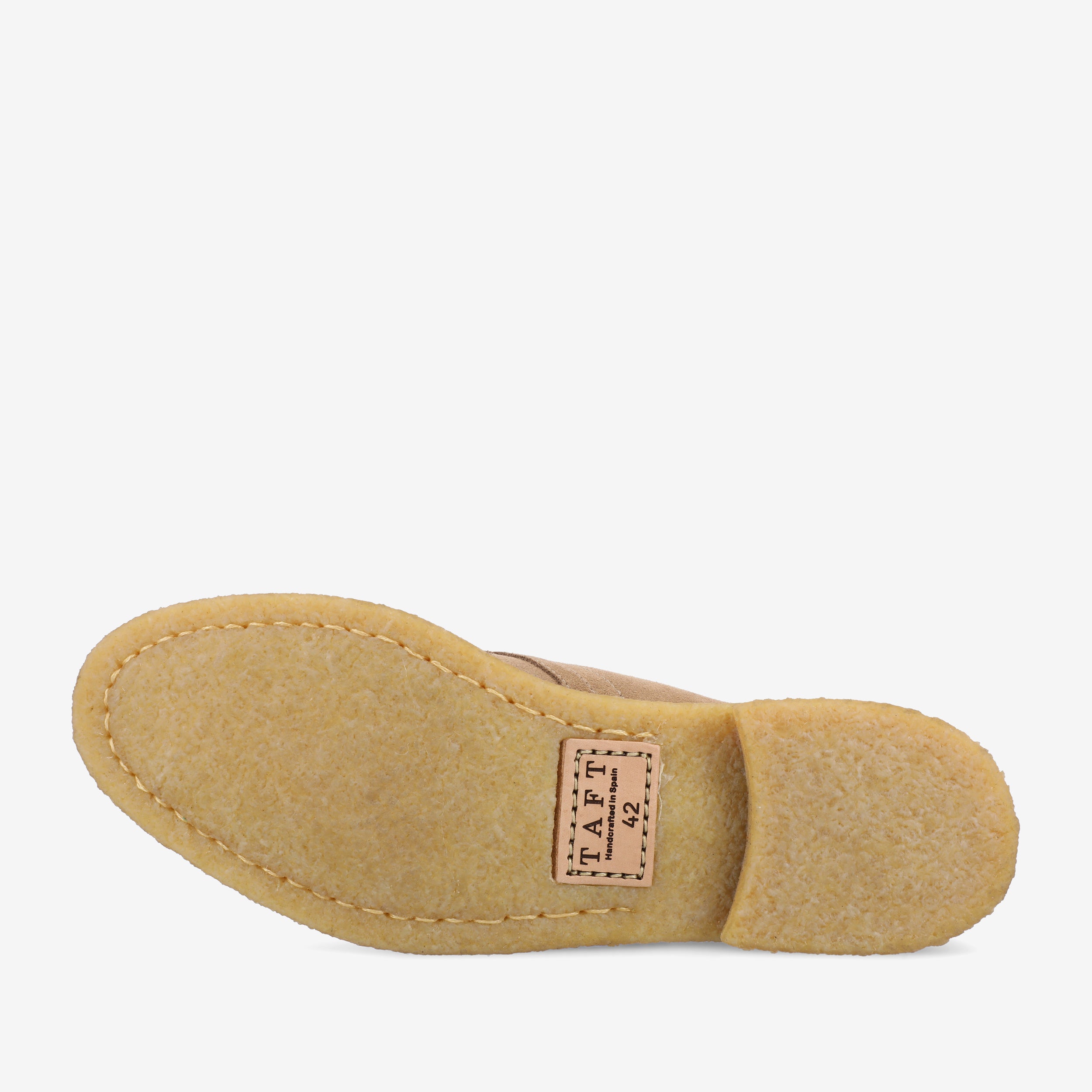 Bottom view of a single tan shoe with a beige, textured sole. A stitched label near the heel area displays the brand name TAFT.