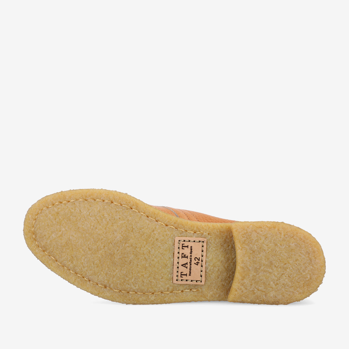 A close-up of a shoe's sole, showcasing its textured surface. A label sewn onto the sole reads TAFT.