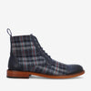 A side view of a dark blue and gray plaid leather lace-up boot with a brown wooden sole.