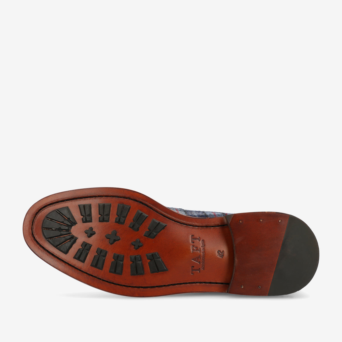 Underside view of a brown leather shoe sole with black rubber grips and stitching details, featuring the brand name TAFT.