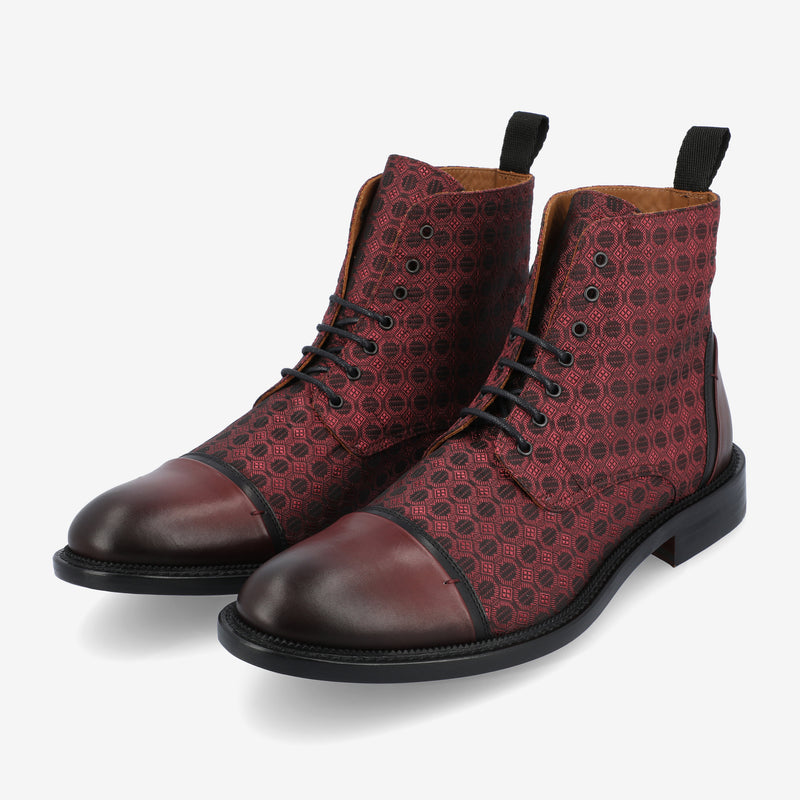 A pair of maroon lace-up boots with a patterned design and black toe caps, featuring a loop on the back for easy wearing.