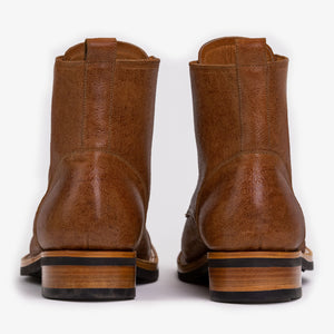 Rear view of a pair of brown leather ankle boots with stacked wooden heels and pull tabs.