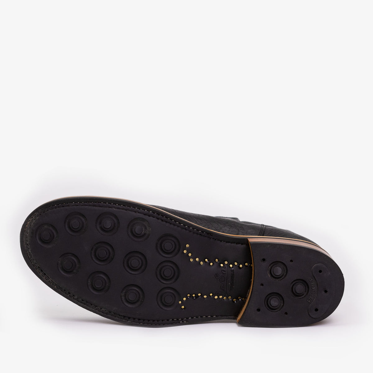 A single black shoe sole with multiple circular grips, displayed on a white background, highlighting the tread pattern and heel design.