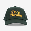 A dark green baseball cap with the words Deep Breaths embroidered in yellow on the front.