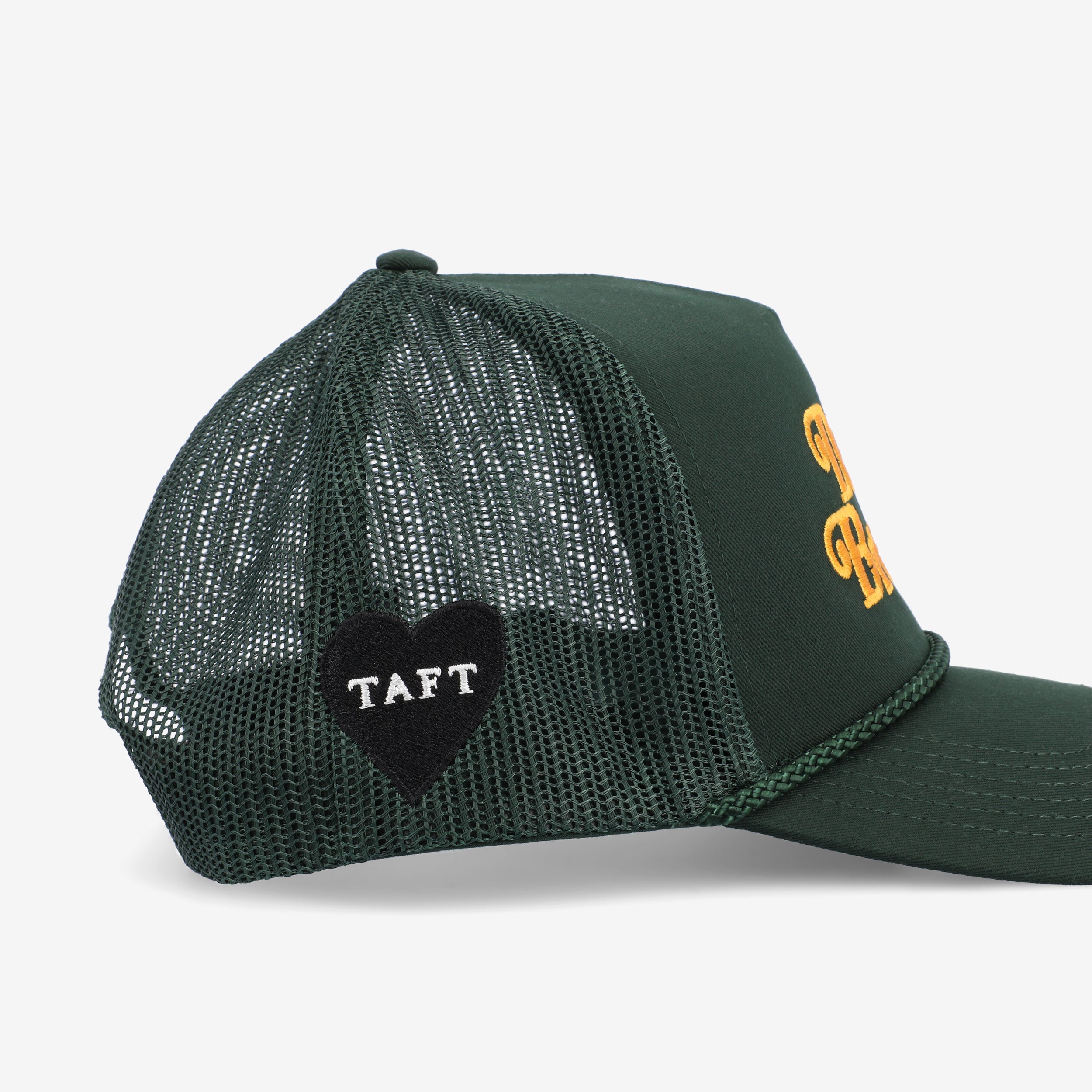 A dark green mesh trucker cap with the word TAFT embroidered on a heart-shaped patch on the side.