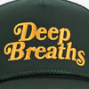 A green hat with the words Deep Breaths embroidered in yellow letters.