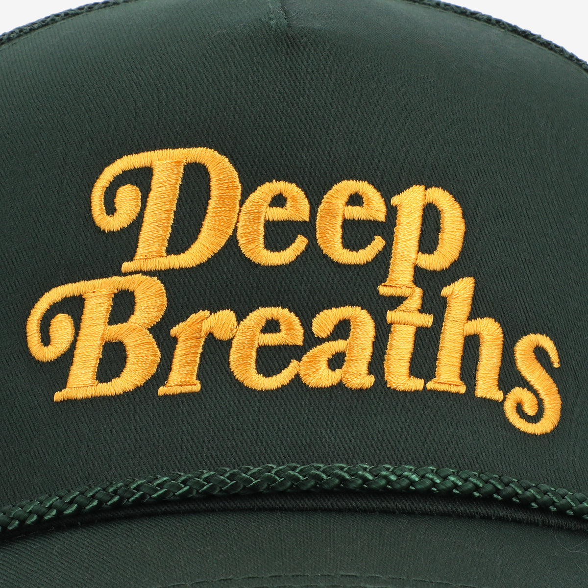 A green hat with the words Deep Breaths embroidered in yellow letters.