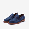 A pair of blue and black patterned penny loafers with brown wooden soles.