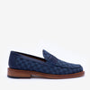 A blue checkered men's loafer with a leather sole, featuring a low heel and slip-on design.