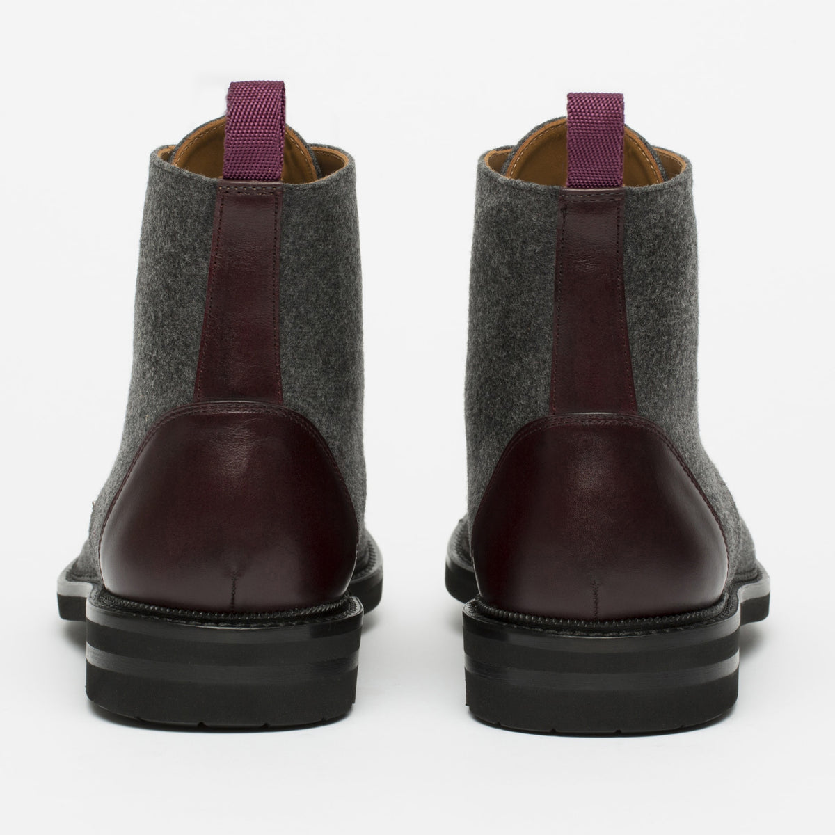 Rear view of a pair of gray and maroon leather boots with purple pull-tabs, featuring black soles.