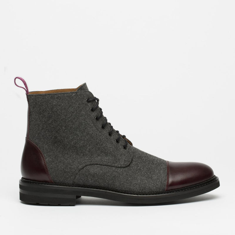 Gray wool ankle boot with dark brown leather cap toe and back, black rubber sole, and red pull tab on the heel.