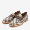 Pair of loafers with a brown and beige checkered fabric design, brown leather accents, and tan soles.