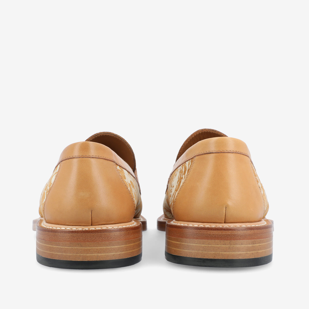 Rear view of a pair of tan leather loafers with wooden soles, featuring a decorative pattern on the sides.