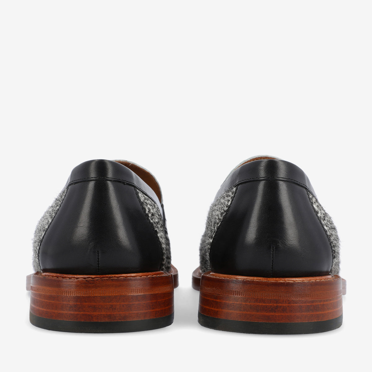 Rear view of two black and gray shoes with wooden soles against a white background.