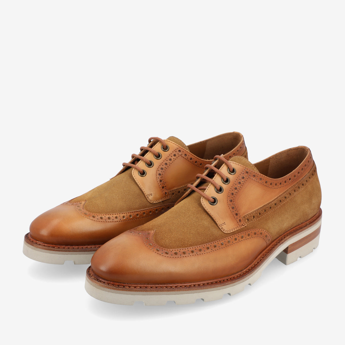 A pair of tan and brown brogue-style oxford shoes with a mix of leather and suede uppers, featuring perforated detailing and white rubber soles.