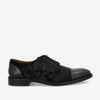 Black men's dress shoe with a lace-up design, featuring a velvet texture on the upper part and a smooth leather cap toe and heel.