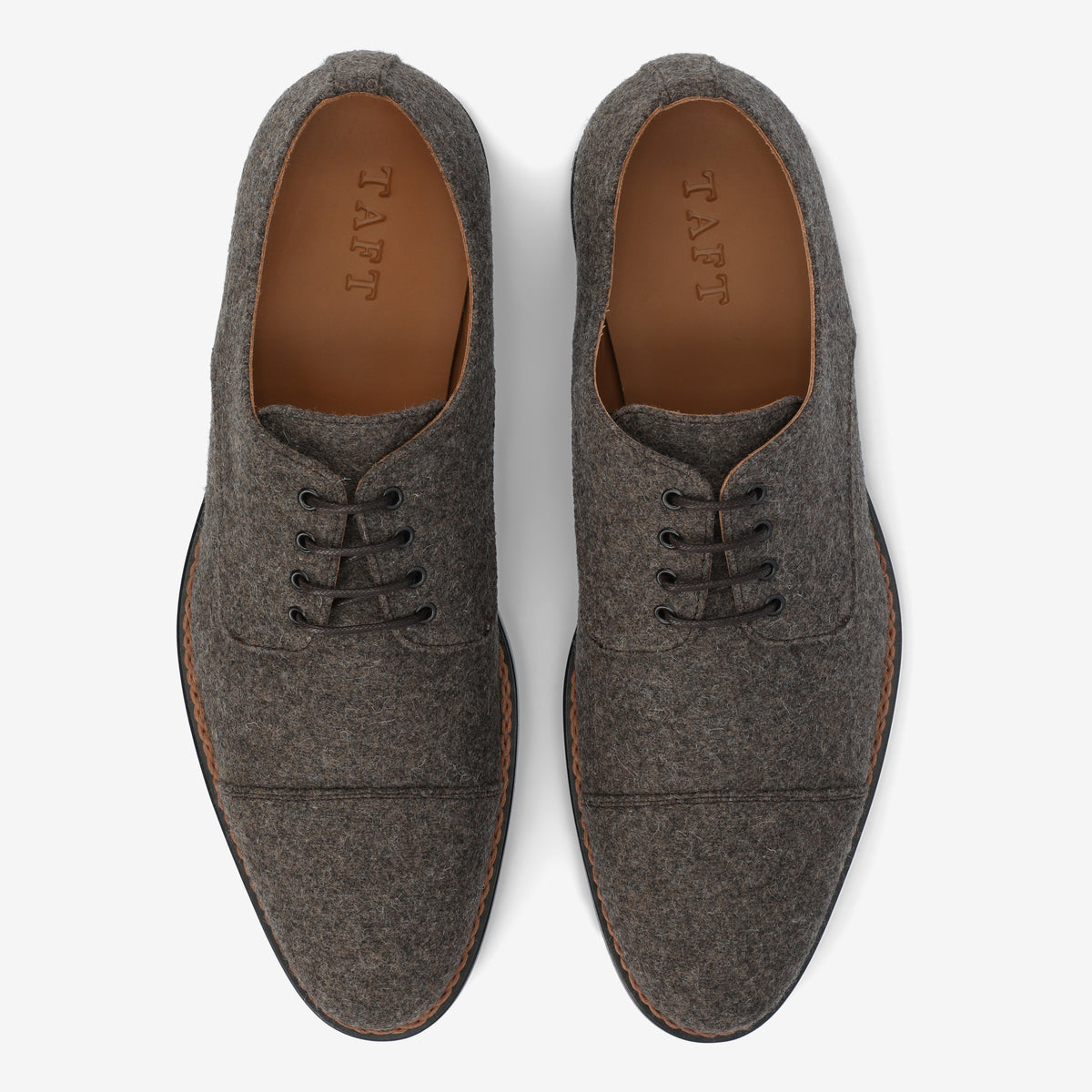 Brown lace-up oxford shoes with dark laces, viewed from above on a white background.