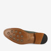 Bottom view of a shoe showcasing its tan leather sole with round rubber grips and the branding TAFT stamped on it.