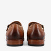 Back view of a pair of brown leather dress shoes with woven detailing and polished finish.