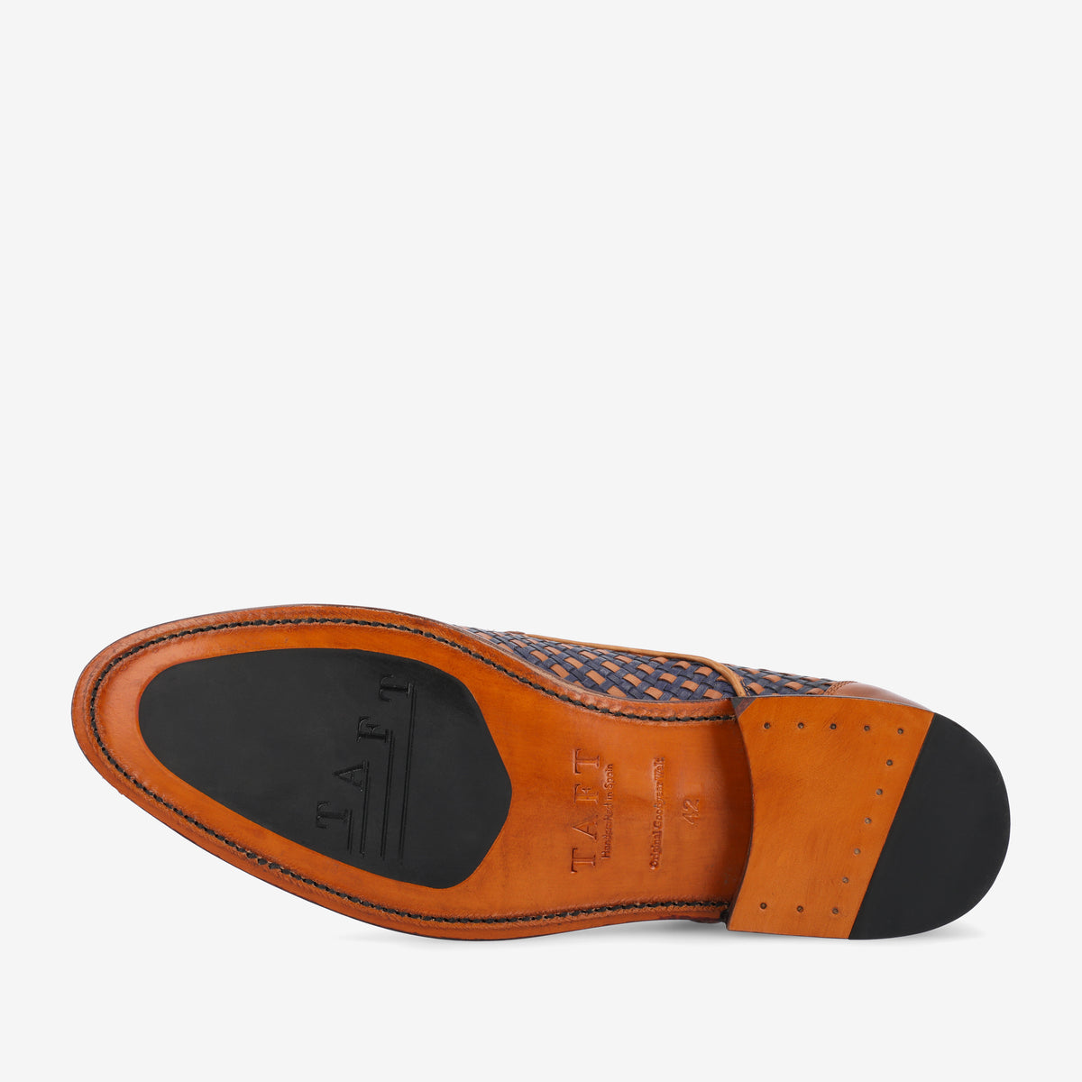 The image shows the sole of a dress shoe with a leather and rubber combination, embossed with the brand name TAFT. The upper part of the shoe features a woven pattern in shades of blue.