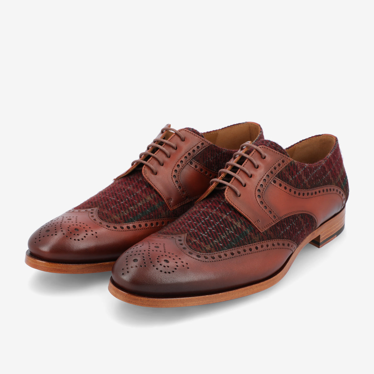 A pair of brown leather and fabric brogue shoes with intricate perforated detailing, featuring a lace-up design and wooden soles, displayed against a white background.