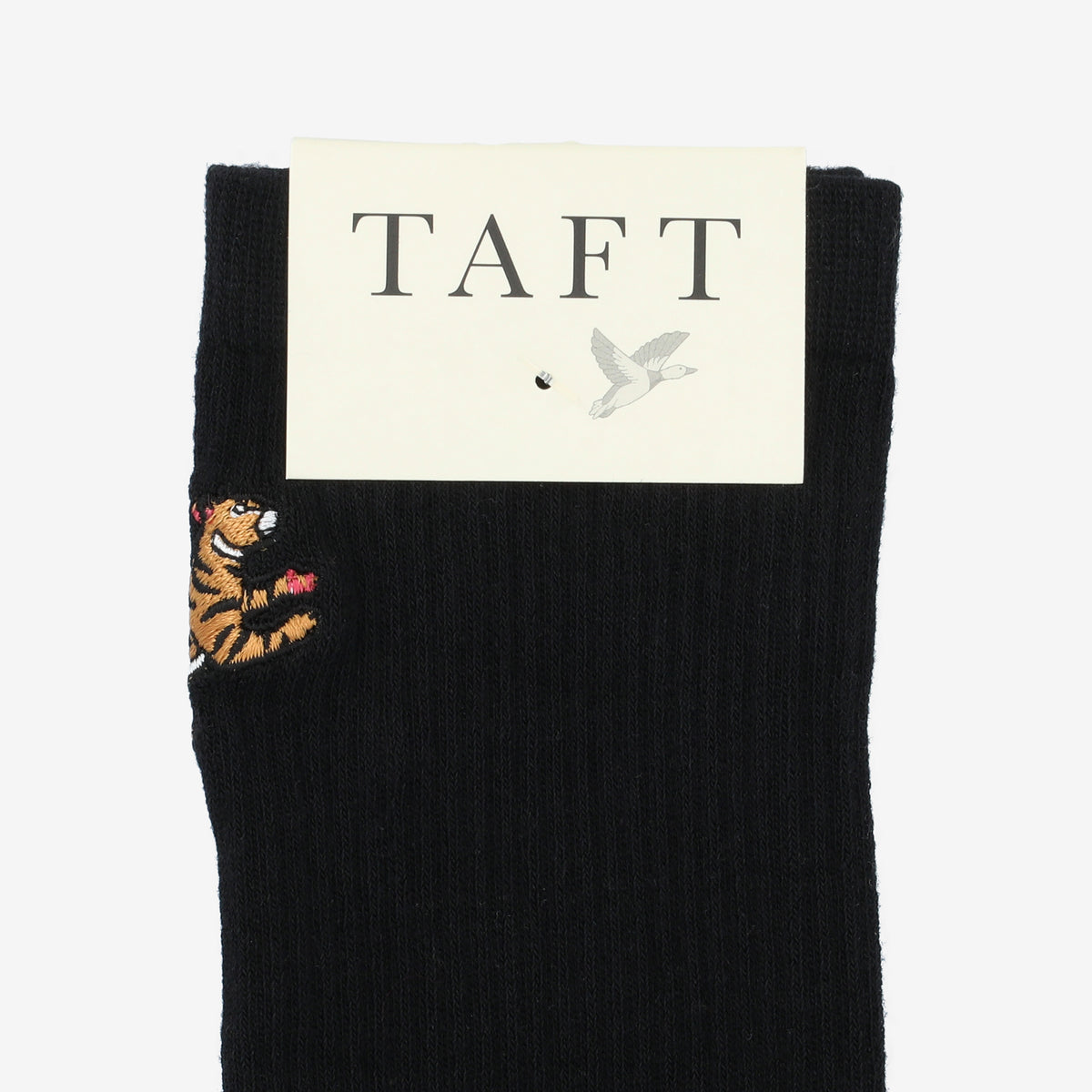 A black sock with an embroidered tiger design and a TAFT tag attached to the top.