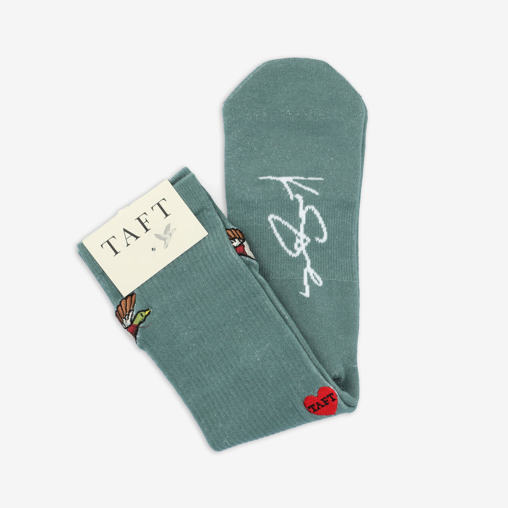 A pair of teal socks featuring a small heart patch and a butterfly design, partially covered by a TAFT label.