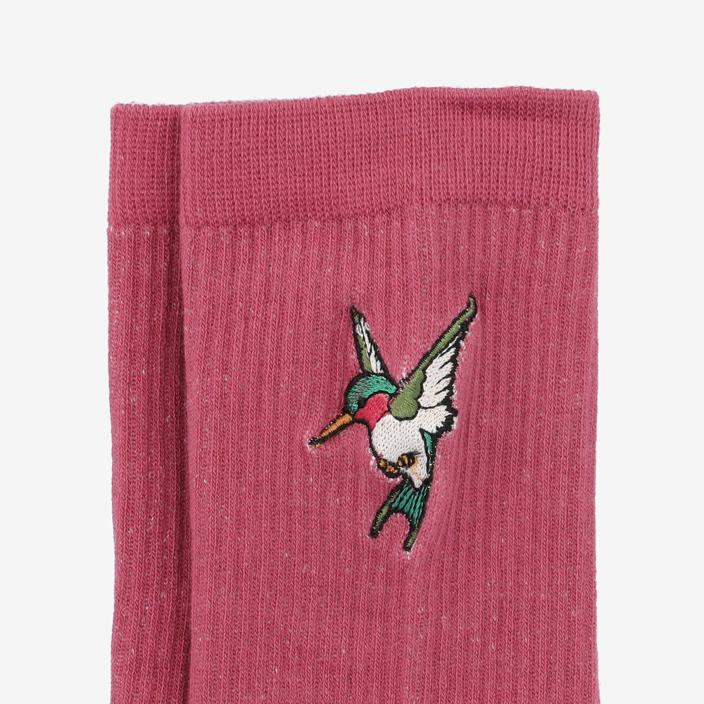 Pink sock with an embroidered flying hummingbird on the side.