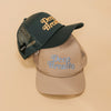 Two mesh trucker caps on a beige background; one dark green with Deep Breaths in yellow lettering and one beige with Deep Breaths in blue lettering.