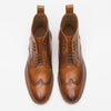 A pair of brown leather brogue ankle boots viewed from above, showcasing detailed perforations and laces.