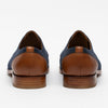 Brown and navy blue dress shoes viewed from the back against a white background.