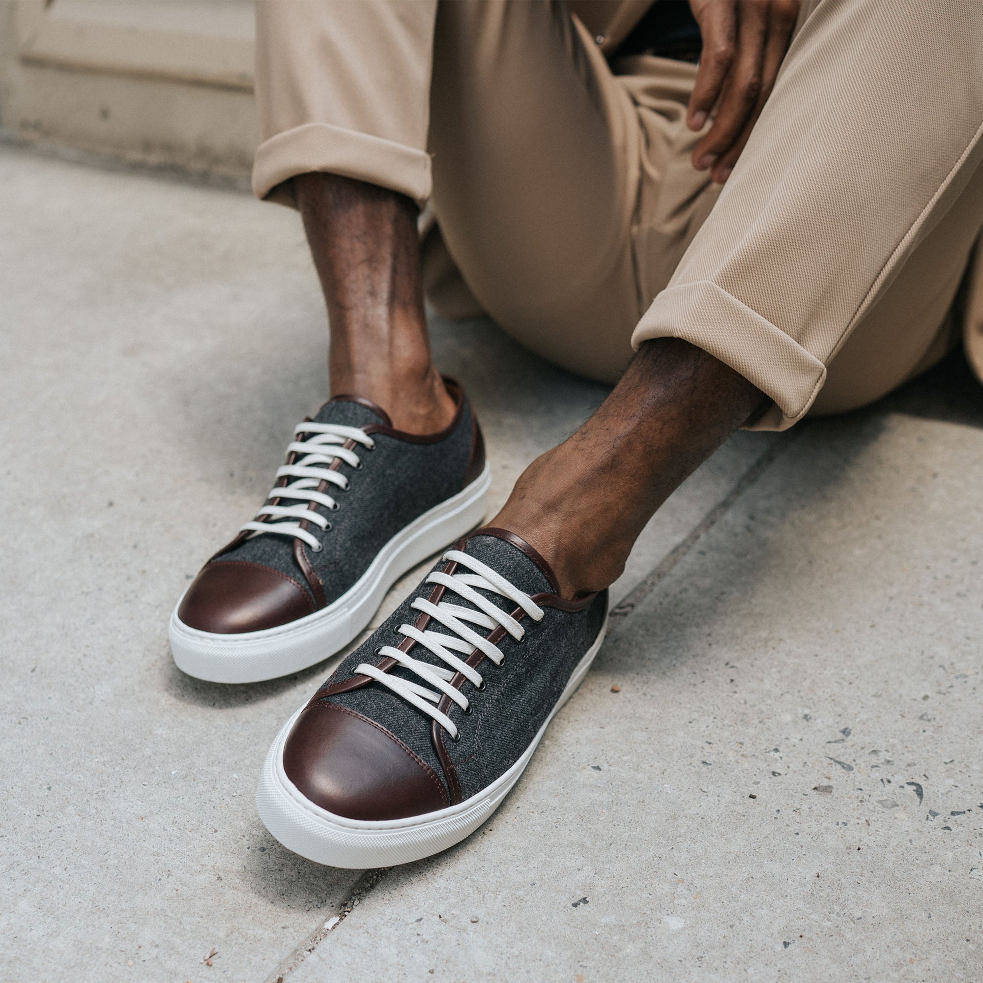 Jack Sneaker in Grey Oxblood on Model sitting on the concrete wearing cuffed khaki pants