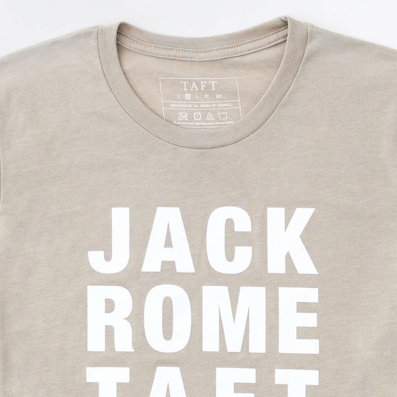 A beige T-shirt with the words JACK ROME TAFT printed in large white capital letters on the front. The interior label shows the brand TAFT and washing instructions.